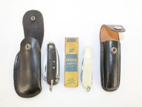 Military jack knife, dated 1943, in leather pouch. Paired with a Victorinox utility knife in leather