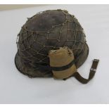 American WW2 M1 Helmet, complete with liner, camouflage netting, and a wound dressing.