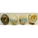 Four decorated ostrich eggs, one on turned wooden stand, 16cm