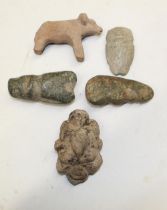 A selection of four carved stone faces and figures of various styles and periods. To include a