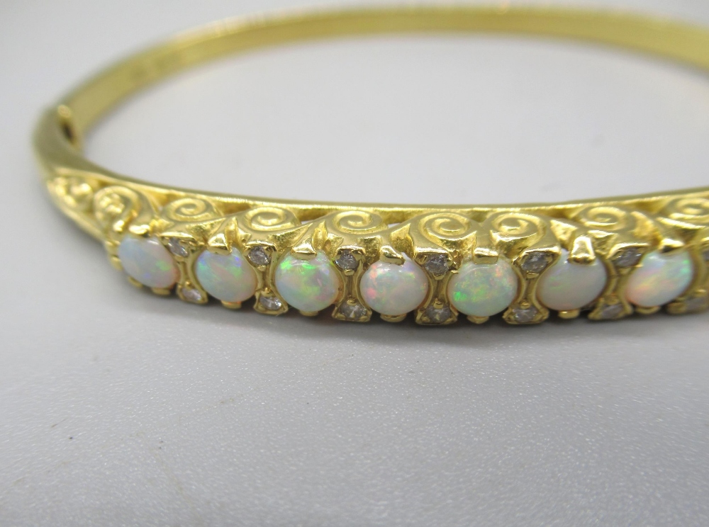 18ct yellow bangle set with nine opals between brilliant cut diamonds on scroll mount, stamped - Image 7 of 12