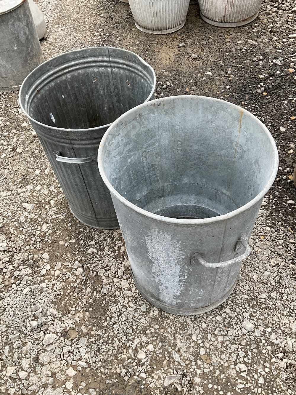 Two metal dustbins for use as planters and garden decor