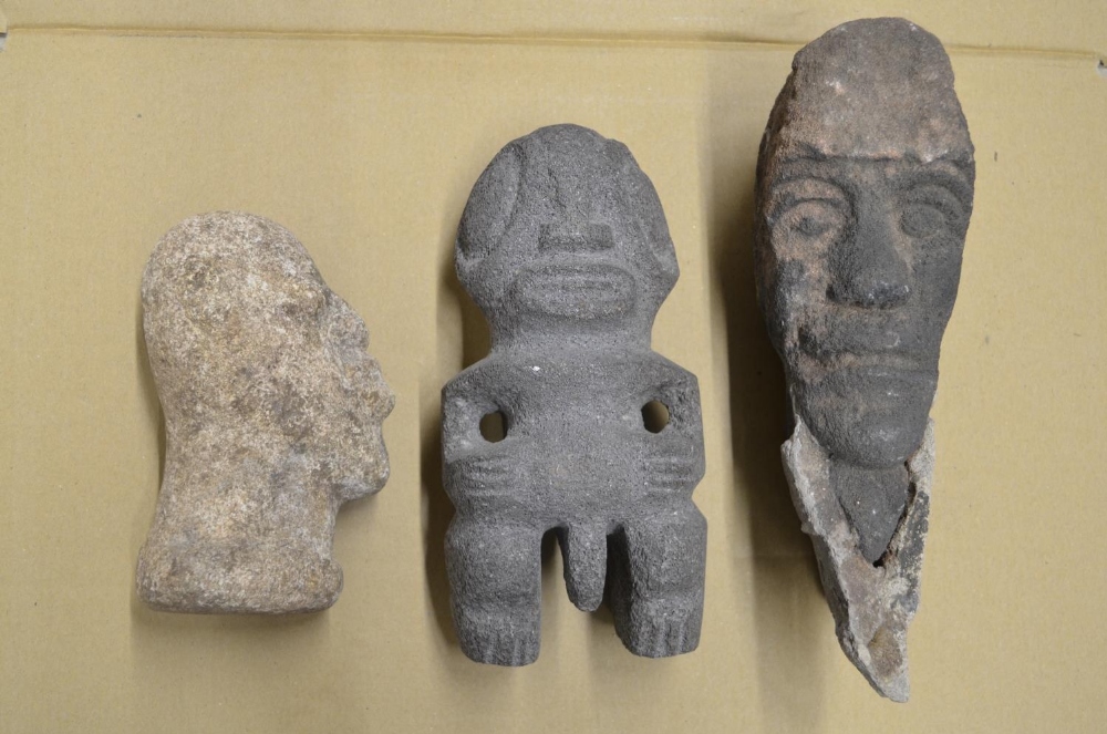 Three carved stone heads depicting an African man, an Aztec fertility symbol, other unknown with - Image 2 of 2