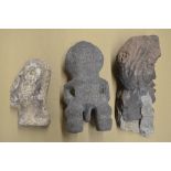 Three carved stone heads depicting an African man, an Aztec fertility symbol, other unknown with