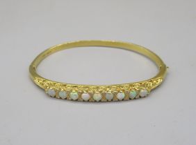 18ct yellow bangle set with nine opals between brilliant cut diamonds on scroll mount, stamped