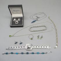 Silver drop pendant necklace set with green stones, matching earrings and ring, and a similar
