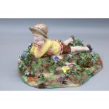 Crown Staffordshire figure group, modelled by T Bayley, signed, modelled as a reclining boy scout on