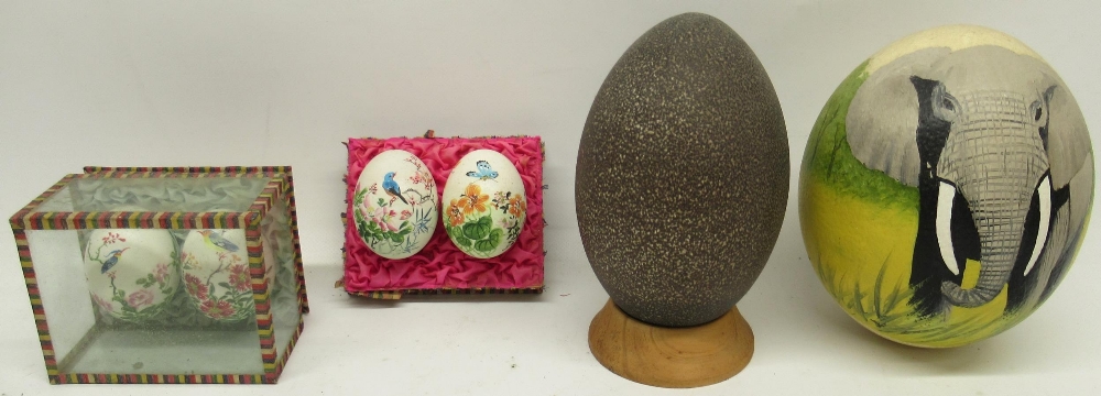 Decorated ostrich eggs, on turned wooden stand, 14cm and other decorated eggs