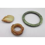 Chinese jade archers thumb ring carved with two dragons, a carved jade fish pendant and a polished