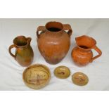 Collection of clay pots including a slipware jug and olive jar, various styles and ages, some with