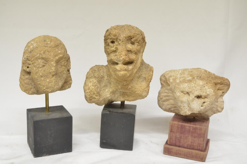 Three carved stone heads, possibly church carvings or similar, all mounted on plinths, max. H23.