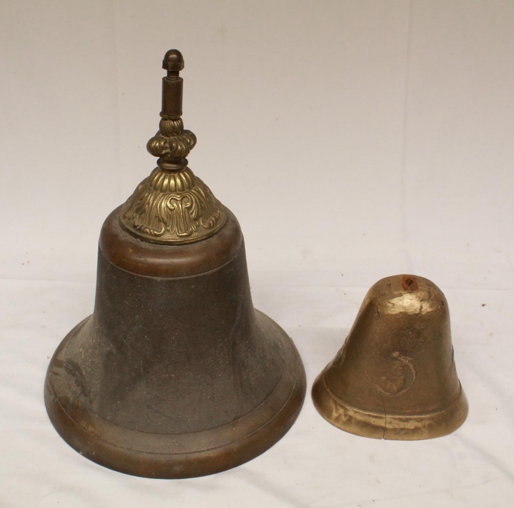 Large brass bell with ornate headstock, lacking original clapper, and a small brass bell casing,