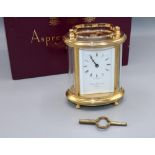 Asprey & Garrard London, 8 day oval brass carriage clock timepiece, signed white enamel Roman