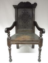 Oak Wainscot type arm chair, lozenge panel back and solid seat on turned supports with ball feet,