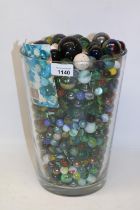 Anne Nilsson design glass vase containing a large quantity of marbles, H28cm