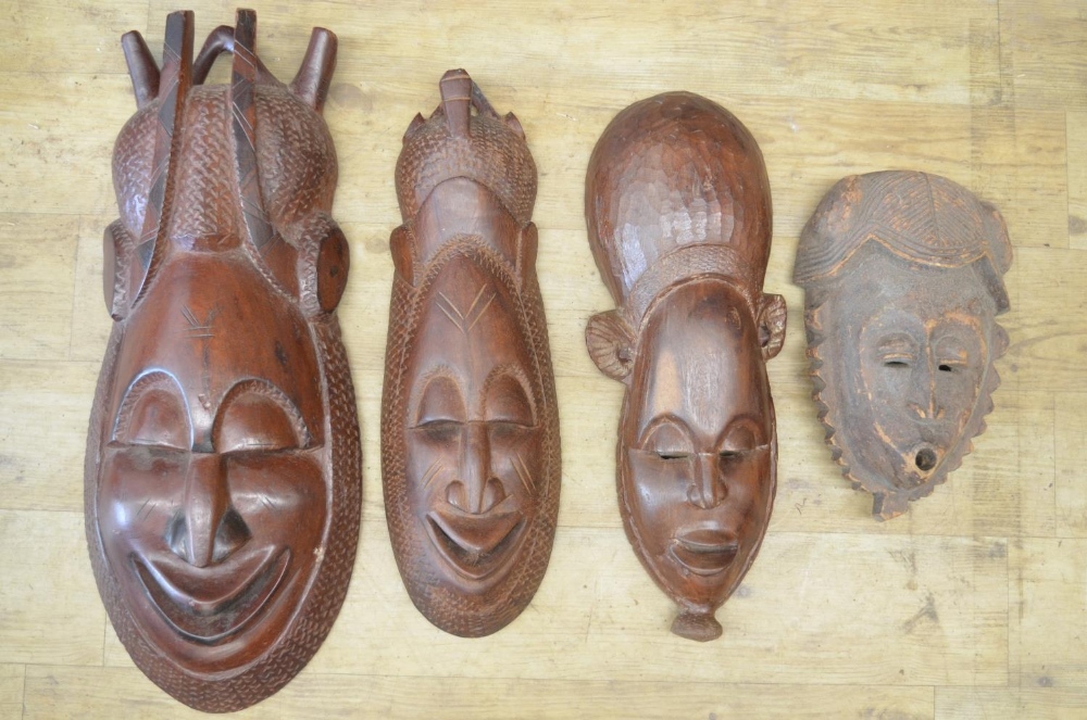 A selection of four carved wooden masks of various styles and time-periods, most likely