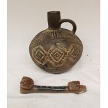 A small embossed ceramic jug in the Indo-Peruvian style. Accompanied by a ceramic flute in