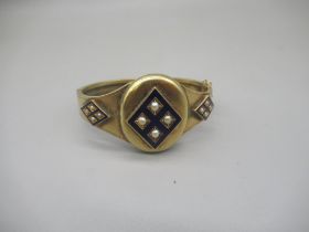 Victorian yellow metal and blue enamel mourning bangle set with pearls, the centre opening to reveal