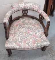 Edwardian walnut salon chair, low curved back on turned supports with casters