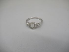 Platinum ring set with central emerald cut diamond, flanked by two baguette cut diamonds, stamped