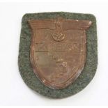 Kuban sleeve shield 1943 on Wehrmacht green backing cloth with backing paper and four prongs intact.