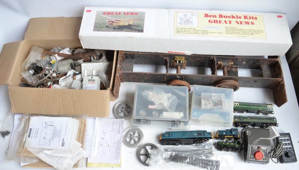 Partially built G gauge steam locomotive with a box of parts, radio control transmitters, books,