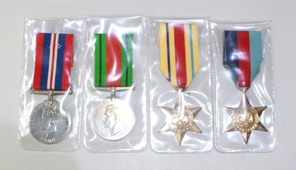 A selection of four medals. To include the Defence Medal, the Africa Star, the 1939-1945 Star, and a