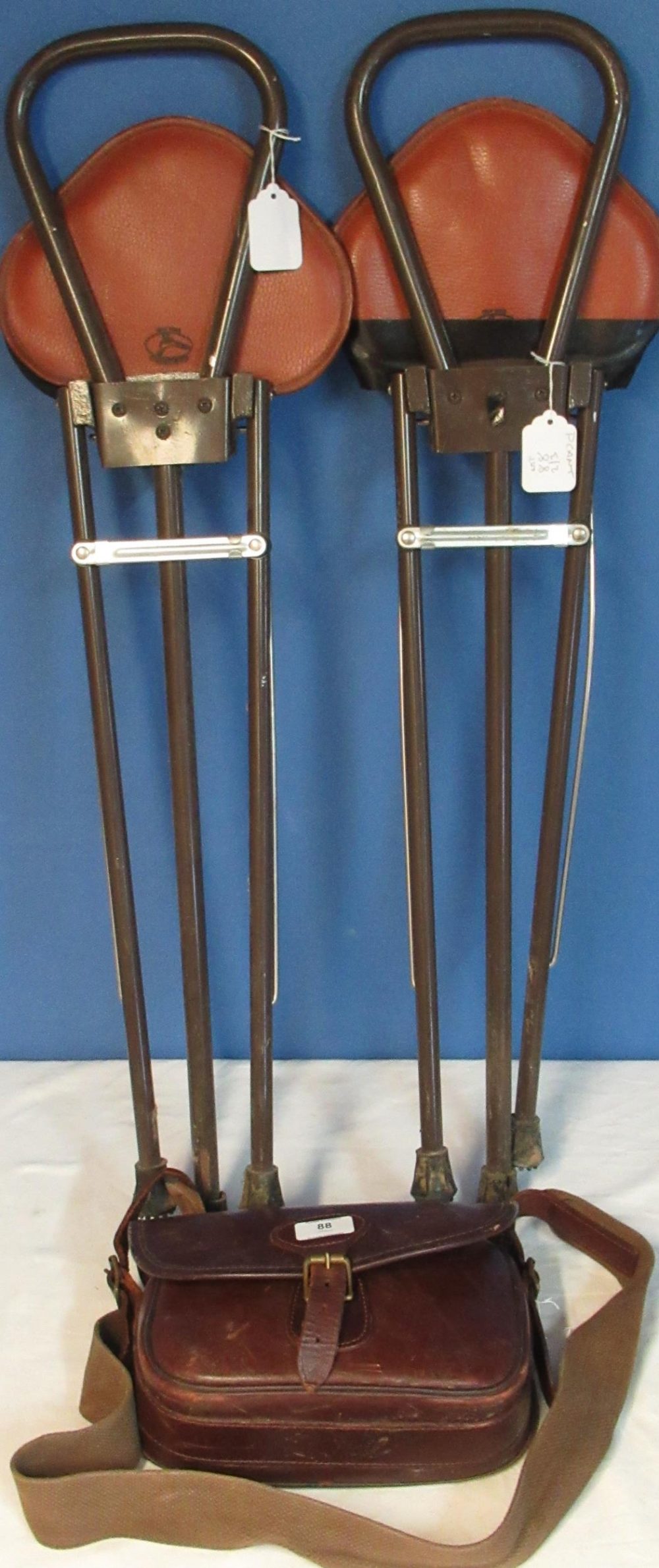 Pair of Gamebird shooting stools and a leather cartridge bag with webbing shoulder strap.