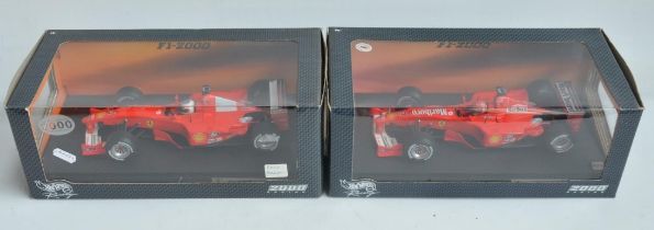 Two 1/18 scale diecast F1 Ferrari F1-2000 models from Hot Wheels Racing with seated driver figures