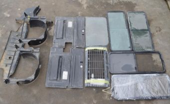 Collection of Land Rover Defender windows, a front grille and other parts (12)