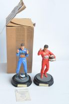 Two hand painted cold cast porcelain figurines of Michael Schumacher, one with shipping box and