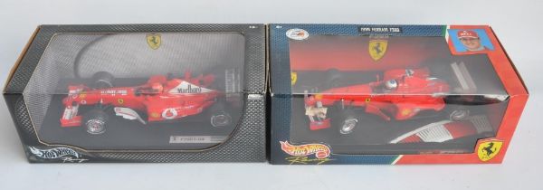 Two 1/18 scale diecast Michael Schumacher F1 Ferrari models from Hot Wheels Racing with seated