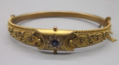 9ct yellow gold hinged bangle, with central floral sapphire and diamond cluster, half of the