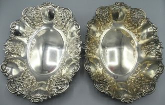 Pair of Victorian silver oval fruit baskets, with pierced and floral repousse raised edges, by