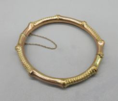 Edwardian 9ct yellow gold bamboo style hinged bangle with alternating plain and textured sections,