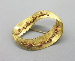 18ct yellow gold oval ribbon brooch with scroll detail set with round cut rubies, stamped 750, W4.