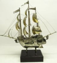 20th century white metal model of a three masted gunship under full sail, on cabriole supports and