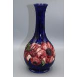 Moorcroft Pottery: Anemone pattern bottle form vase, red flowers on dark blue ground, H22cm