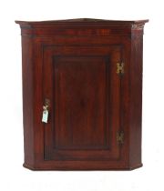 Property of a lady - a George III oak corner wall cabinet with fielded panelled door enclosing