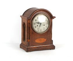Property of a gentleman - an early 20th century oak & inlaid arched cased mantel clock, the American