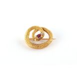 A yellow gold ruby & diamond set snake brooch, the oval cut ruby measuring approximately 4.80 by 4.