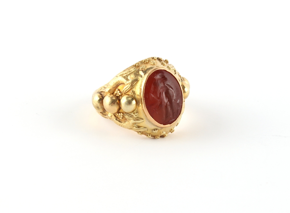 An unmarked high carat yellow gold ring set with an antique carved carnelian intaglio, approximately