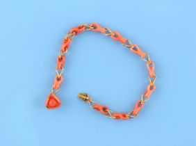 A yellow gold & carved coral link bracelet, with pierced chain links, with carved coral stylised