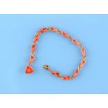 A yellow gold & carved coral link bracelet, with pierced chain links, with carved coral stylised