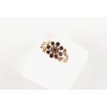 A 19th century unmarked yellow gold garnet & seed pearl cluster ring, with bifurcated shoulders,