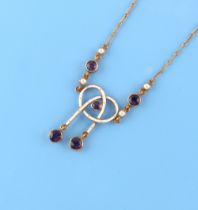 An Edwardian 15ct gold amethyst seed pearl & white enamel chain necklace, 15.75ins. (40cms.) long.