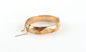 Property of a lady - a 9ct gold hinged bangle, with faceted decoration, Birmingham 1965,