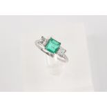 A Columbian emerald & diamond three stone ring, the centre square cut emerald weighing approximately