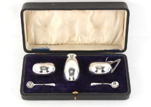 Property of a gentleman - an Arts & Crafts style silver three piece condiment set, with spoons (