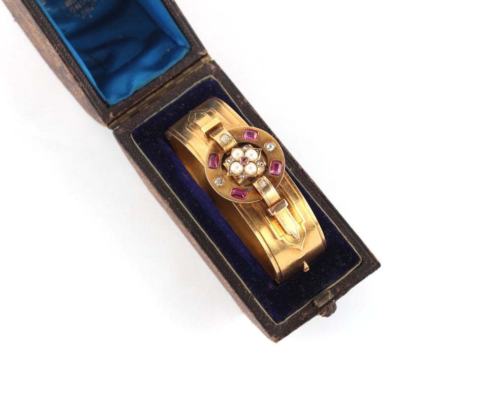 A Victorian high carat gold hinged bangle set with rubies, diamonds & seed pearls, the four well